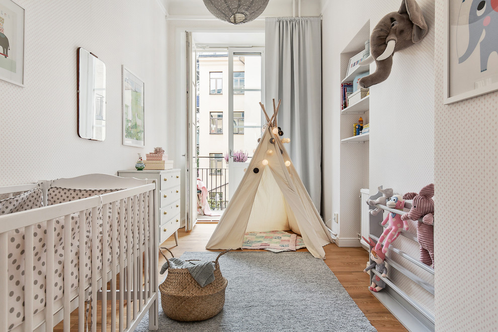 Neutrales, Großes Skandinavisches Babyzimmer mit braunem Holzboden und weißer Wandfarbe in Stockholm