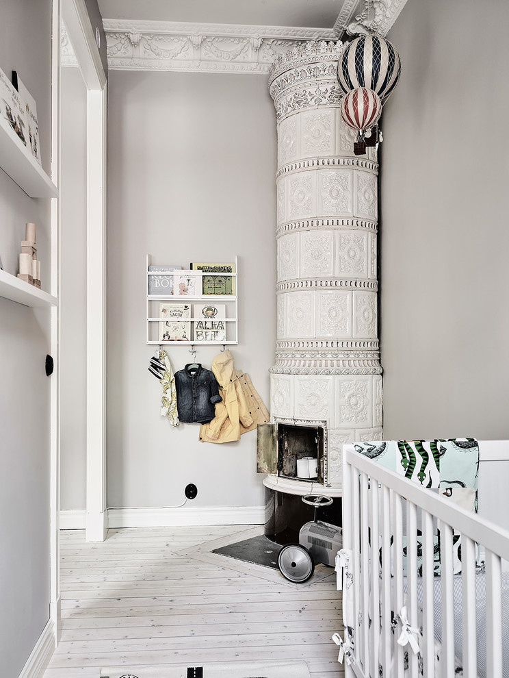Mittelgroßes, Neutrales Nordisches Babyzimmer mit grauer Wandfarbe, hellem Holzboden und weißem Boden in Göteborg