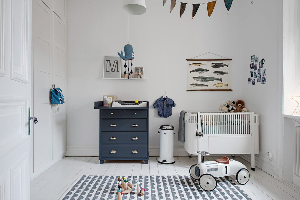 Diseño de habitación de bebé neutra nórdica de tamaño medio con paredes blancas, suelo de madera pintada y suelo blanco