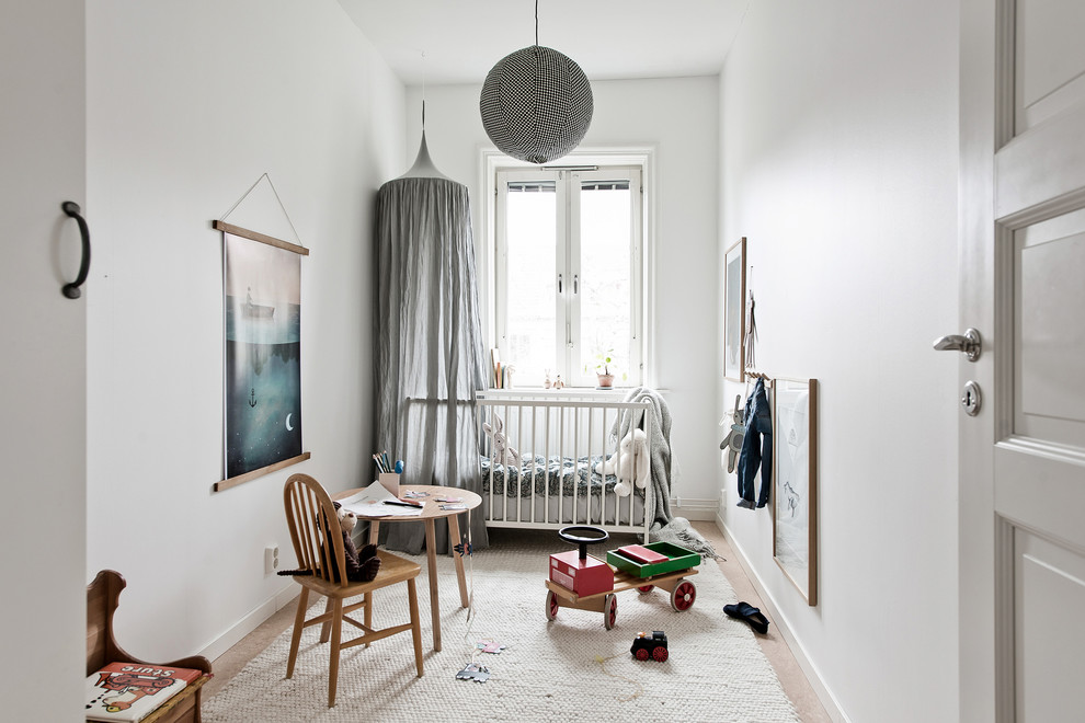 Cette image montre une chambre de bébé neutre nordique avec un mur blanc et un sol beige.