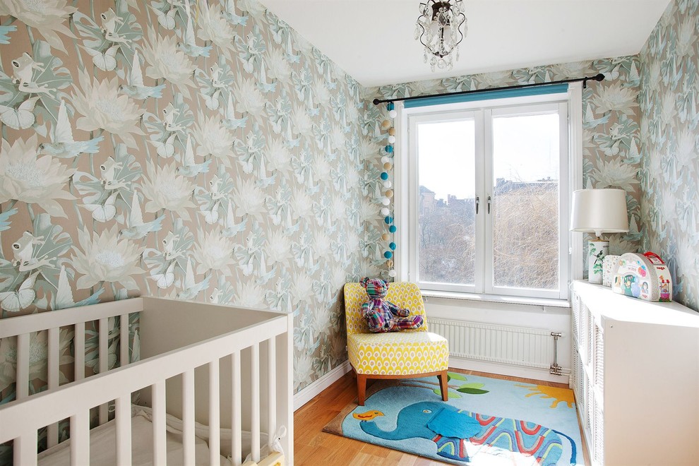 Réalisation d'une petite chambre de bébé neutre tradition avec un mur multicolore, parquet clair et un sol orange.
