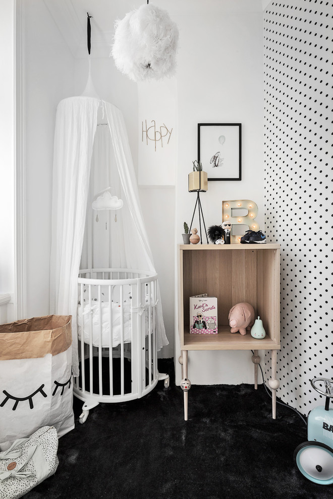 ストックホルムにある低価格の中くらいな北欧スタイルのおしゃれな赤ちゃん部屋 (黒い壁、カーペット敷き、男女兼用) の写真