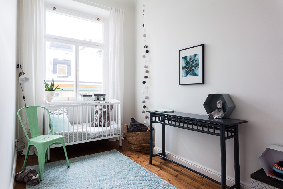 На фото: нейтральная комната для малыша среднего размера в скандинавском стиле с белыми стенами и полом из винила с