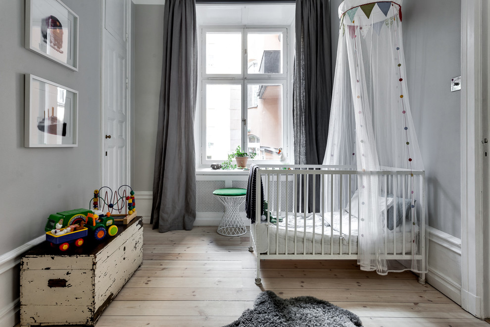 Neutrales, Mittelgroßes Nordisches Babyzimmer mit grauer Wandfarbe, hellem Holzboden und beigem Boden in Stockholm