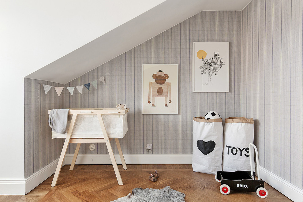 Medium sized scandi gender neutral nursery in Stockholm with grey walls and medium hardwood flooring.