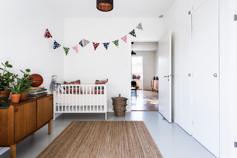 Foto på ett mellanstort skandinaviskt könsneutralt babyrum, med vita väggar, målat trägolv och grått golv