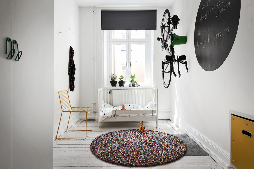 Пример оригинального дизайна: нейтральная комната для малыша среднего размера в скандинавском стиле с белыми стенами, деревянным полом и белым полом