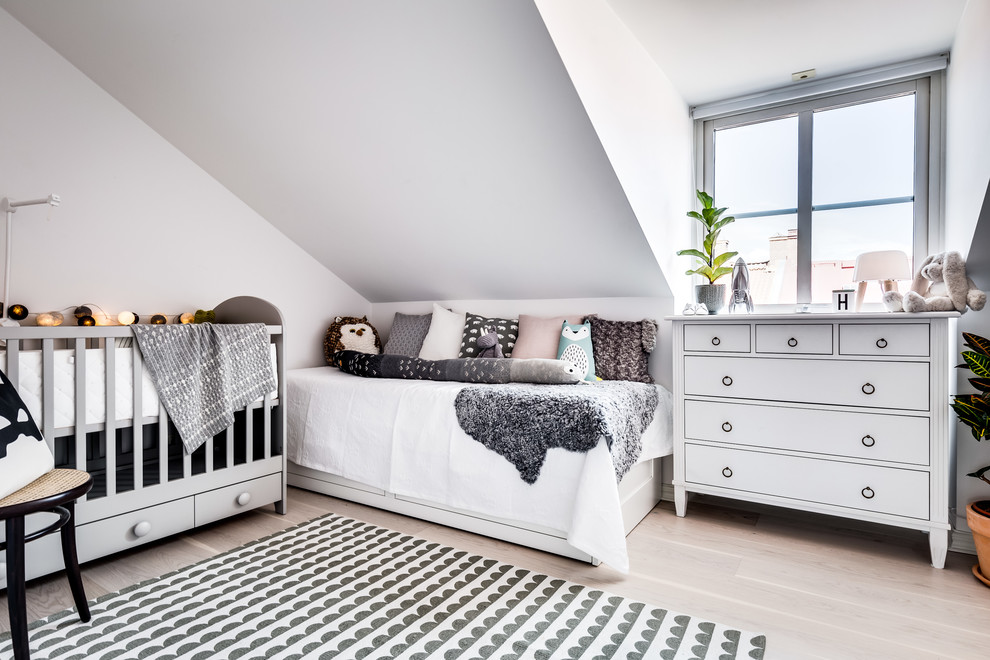 Diseño de habitación de bebé neutra nórdica con paredes blancas, suelo de madera clara y suelo beige