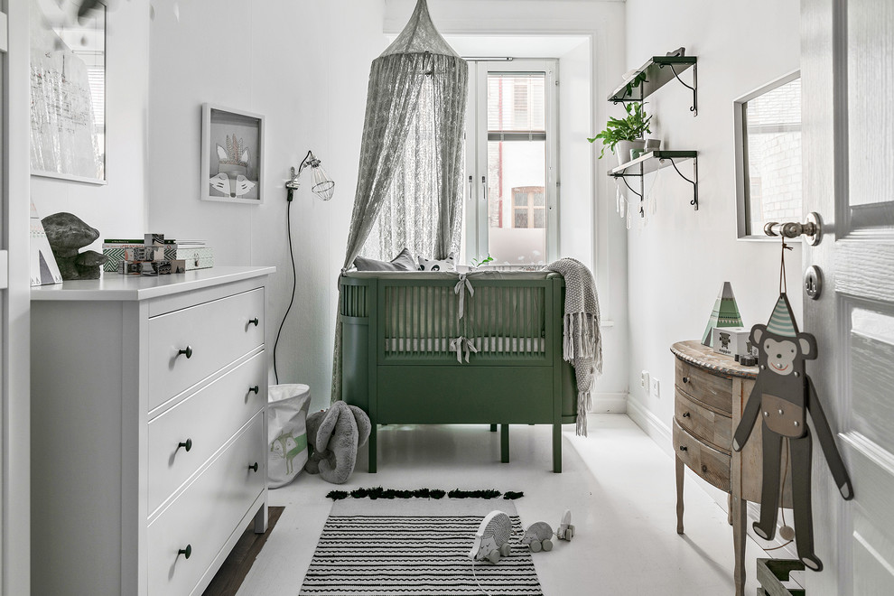 На фото: нейтральная комната для малыша в скандинавском стиле с белыми стенами и белым полом с