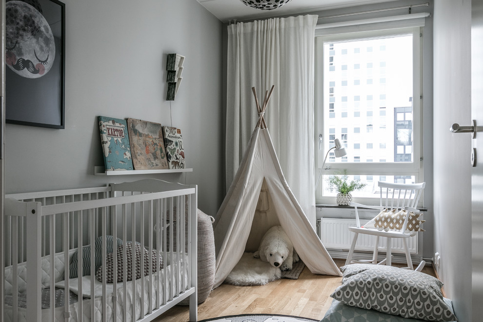 Inspiration for a scandinavian gender neutral nursery in Stockholm with white walls, light hardwood flooring and beige floors.