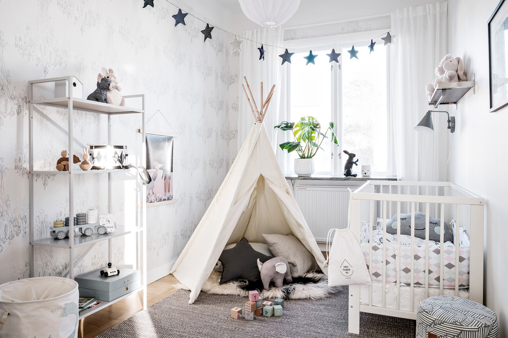 Mittelgroßes, Neutrales Nordisches Babyzimmer mit weißer Wandfarbe, hellem Holzboden und beigem Boden in Göteborg