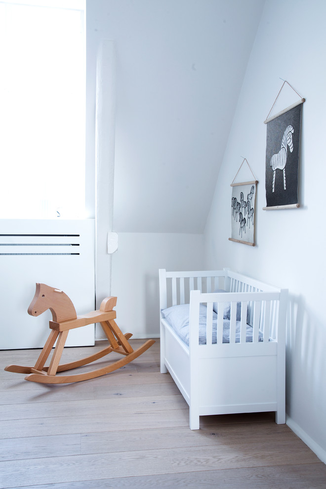Foto de habitación de bebé neutra nórdica de tamaño medio con paredes blancas