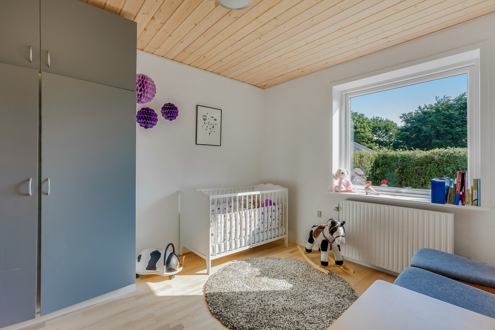 На фото: комната для малыша в стиле кантри с белыми стенами, светлым паркетным полом и бежевым полом для девочки