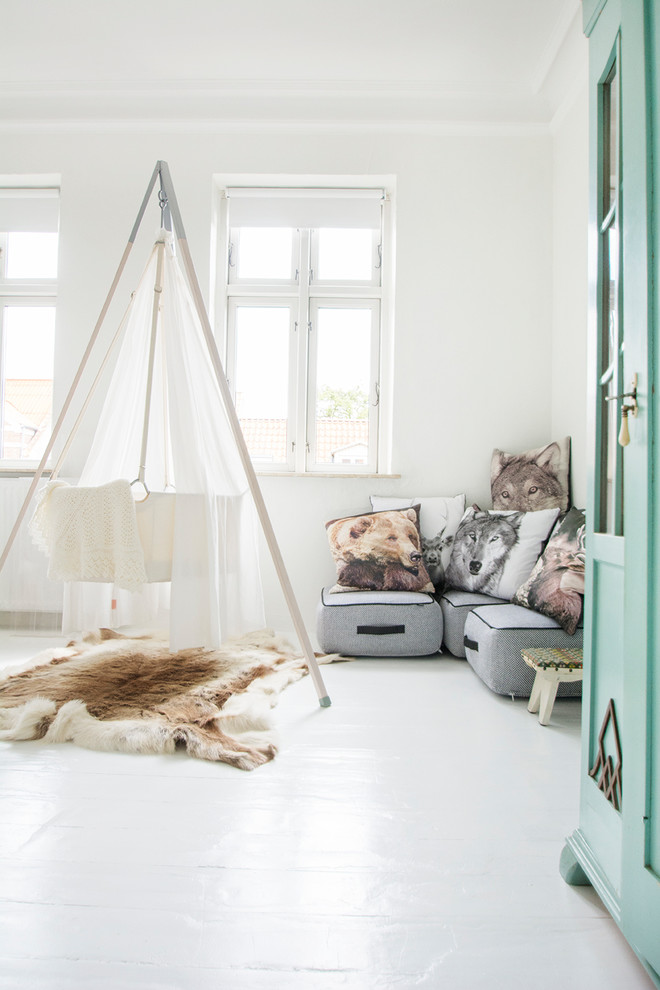 На фото: нейтральная комната для малыша в скандинавском стиле с белыми стенами, деревянным полом и белым полом