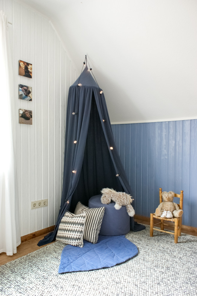 Aménagement d'une chambre de bébé garçon campagne de taille moyenne avec un mur bleu, sol en stratifié et un sol marron.