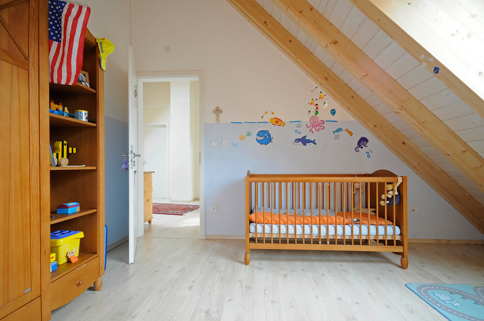 Idéer för att renovera ett mellanstort vintage könsneutralt babyrum, med blå väggar, ljust trägolv och beiget golv