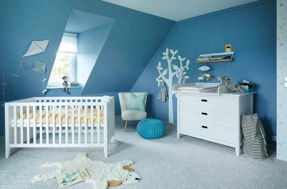 Immagine di una cameretta per neonato nordica di medie dimensioni con pareti blu, moquette e pavimento grigio