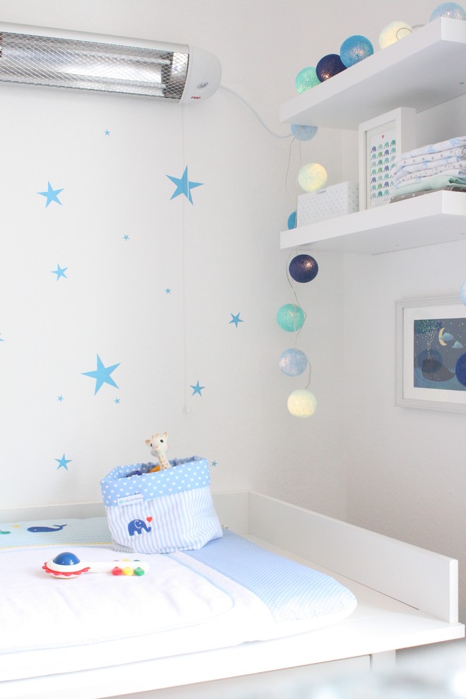 Cette image montre une chambre de bébé garçon nordique de taille moyenne avec un mur blanc, un sol marron et parquet foncé.