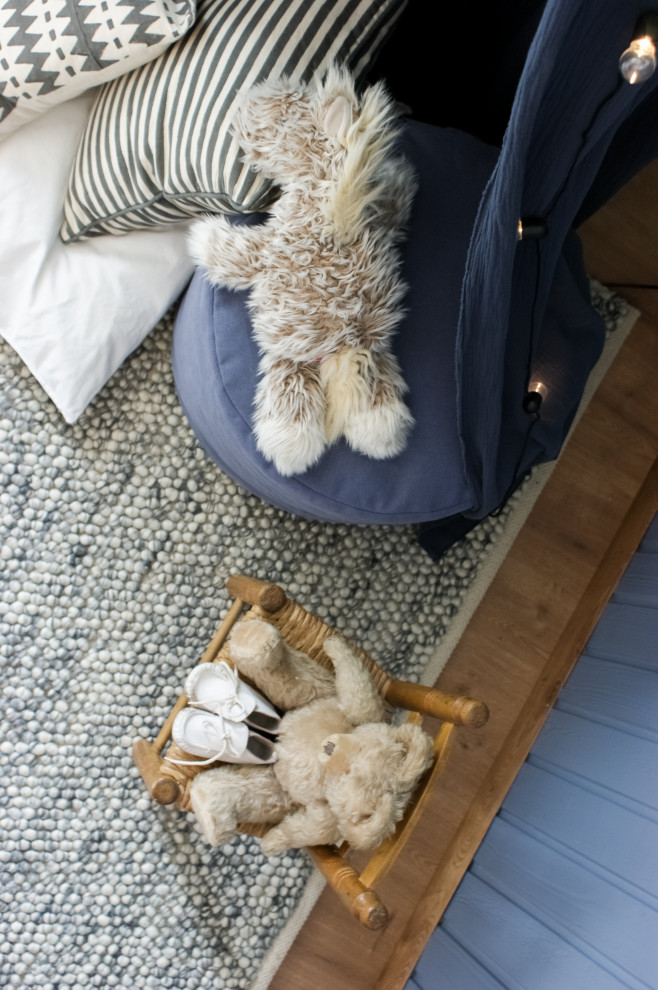 На фото: комната для малыша среднего размера в стиле кантри с синими стенами, полом из ламината и коричневым полом для мальчика
