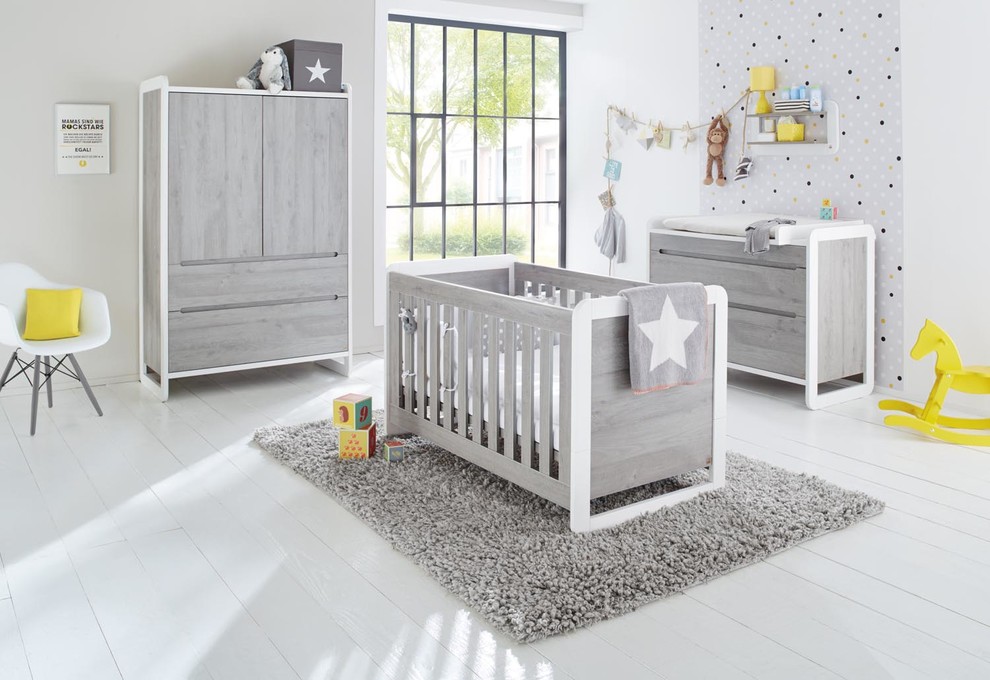 Ejemplo de habitación de bebé neutra contemporánea de tamaño medio con paredes grises y suelo de madera clara