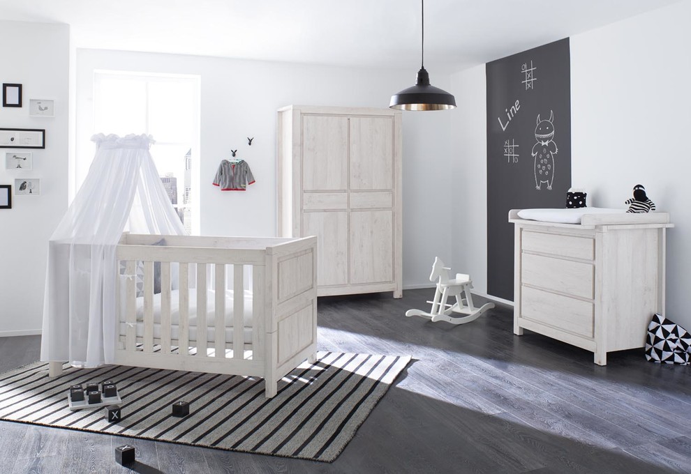 Стильный дизайн: нейтральная комната для малыша в современном стиле с белыми стенами, темным паркетным полом и серым полом - последний тренд