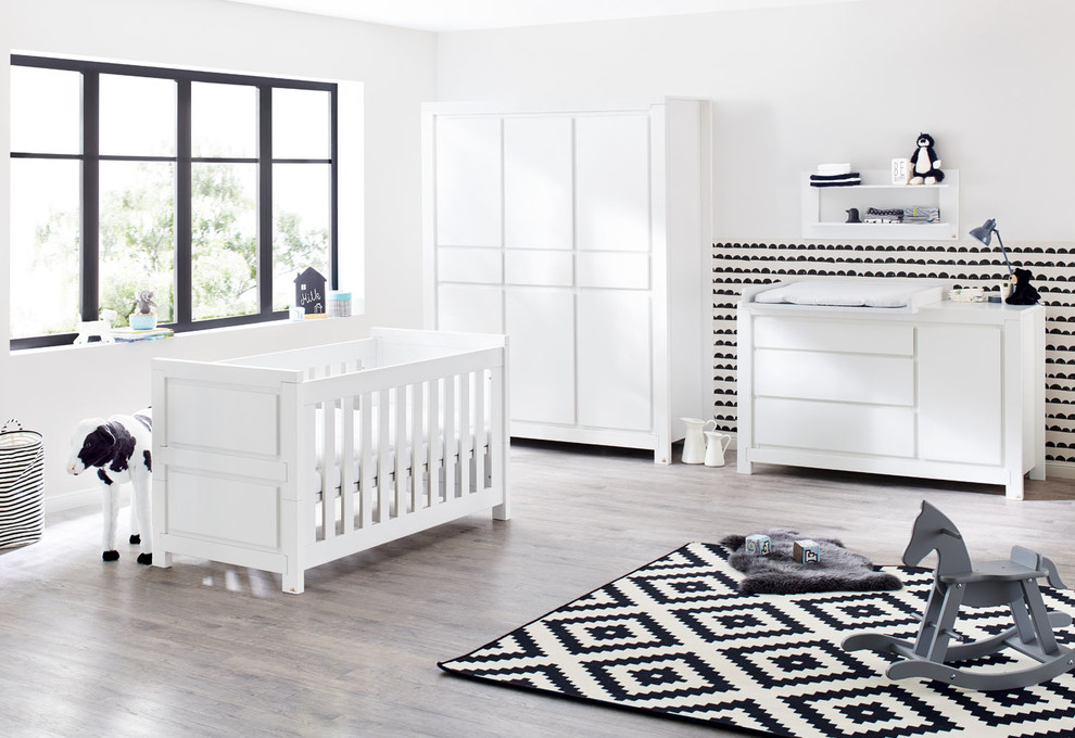 Cette photo montre une grande chambre de bébé neutre tendance avec un mur blanc, parquet clair et un sol gris.