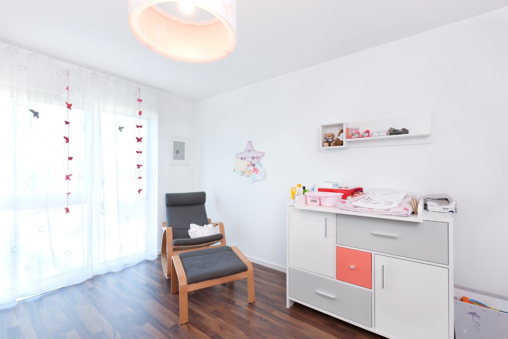 Mittelgroßes Modernes Babyzimmer mit weißer Wandfarbe, dunklem Holzboden und braunem Boden in Stuttgart