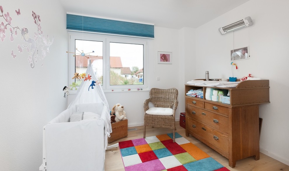 Kleines Modernes Babyzimmer mit weißer Wandfarbe, hellem Holzboden und beigem Boden in Stuttgart