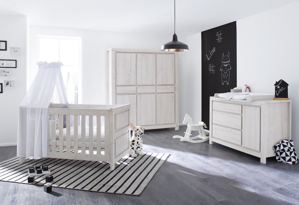 Neutrales Modernes Babyzimmer mit weißer Wandfarbe und dunklem Holzboden in Hamburg