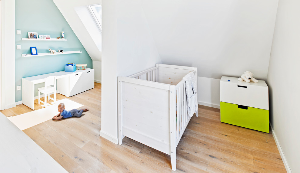 Mittelgroßes, Neutrales Modernes Babyzimmer mit weißer Wandfarbe und braunem Holzboden in Stuttgart