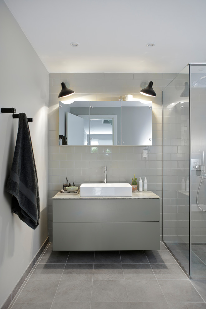 Idee per una stanza da bagno con doccia nordica di medie dimensioni con ante lisce, ante grigie, piastrelle grigie, pareti grigie e lavabo a bacinella