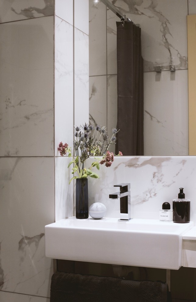 This is an example of a small modern shower room bathroom in Copenhagen with marble tiles, a wall-mounted sink and white worktops.