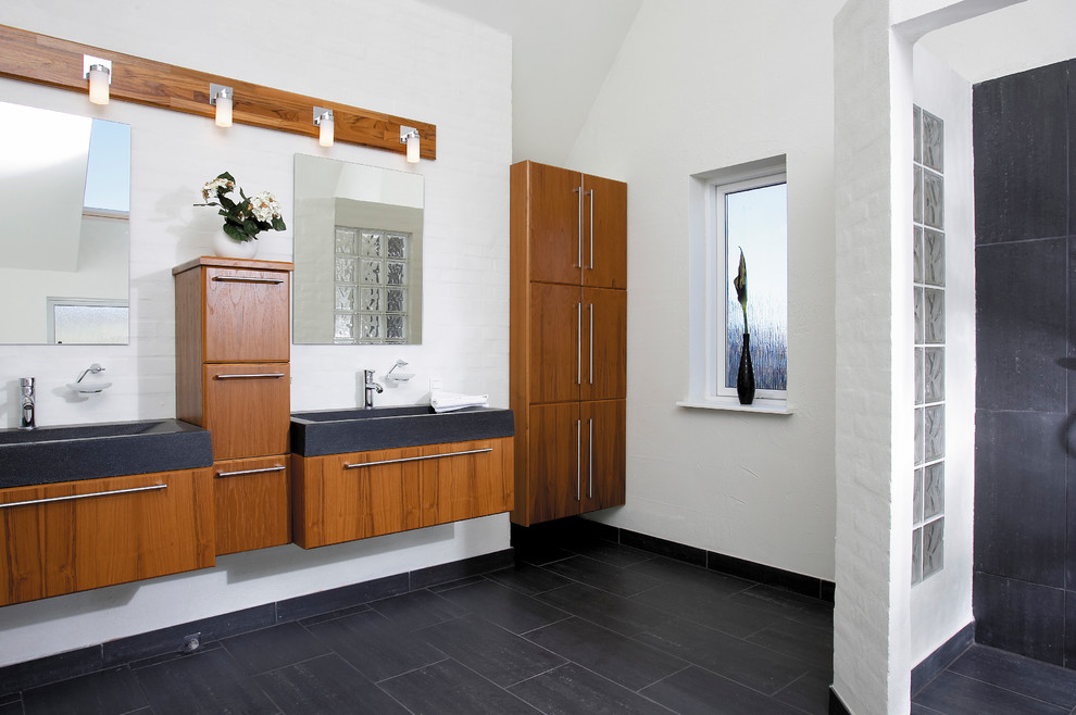 Foto di una stanza da bagno padronale scandinava di medie dimensioni con consolle stile comò, ante in legno bruno, pareti bianche, lavabo integrato, top in quarzo composito e top nero