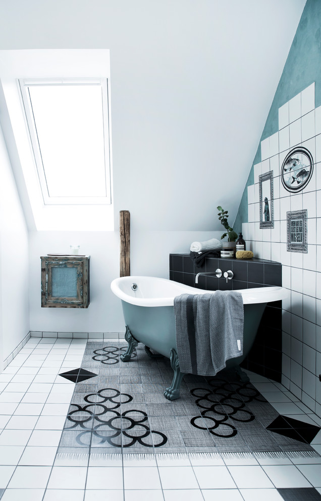 Bild på ett mellanstort funkis badrum, med ett badkar med tassar, svart och vit kakel, vit kakel och porslinskakel