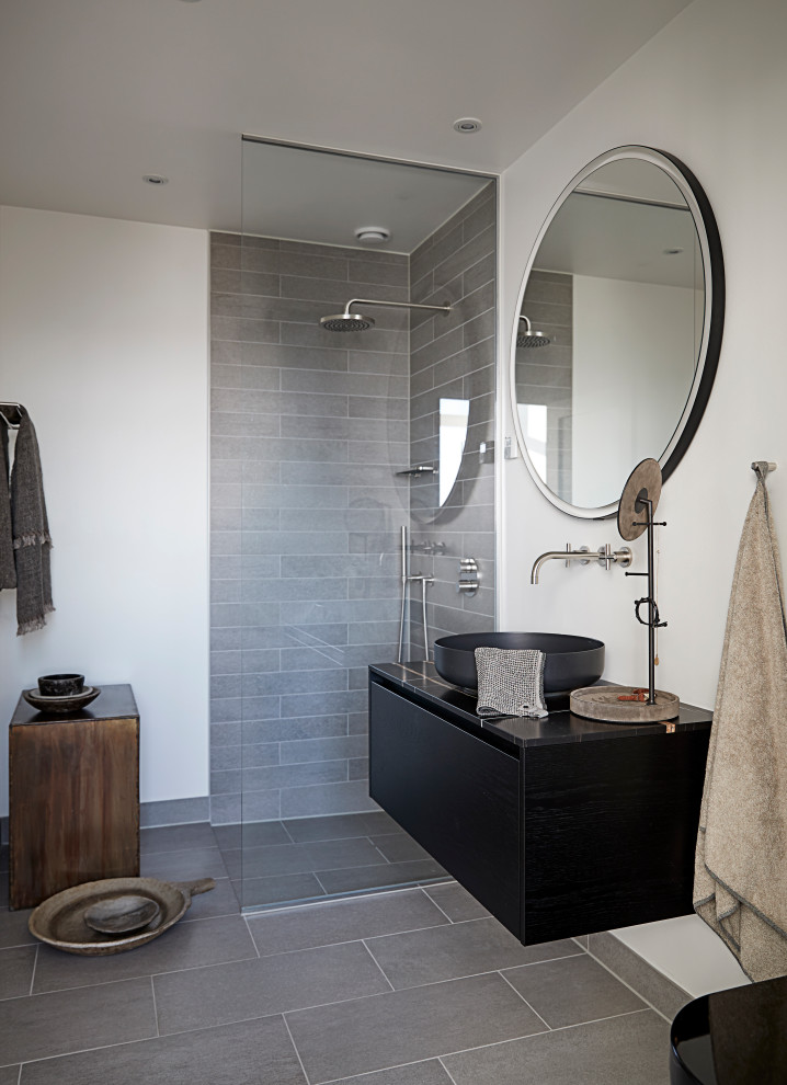 Idéer för ett modernt svart badrum, med släta luckor, svarta skåp, en vägghängd toalettstol, grå kakel, vita väggar, ett fristående handfat, marmorbänkskiva, grått golv och med dusch som är öppen