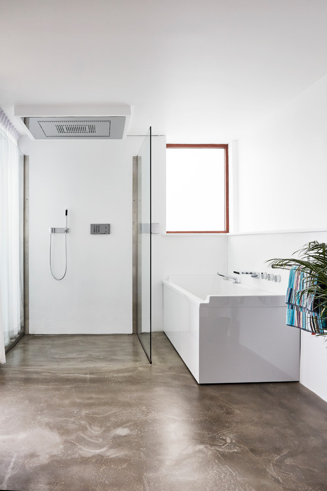 Modelo de cuarto de baño principal escandinavo grande con bañera esquinera, ducha a ras de suelo, paredes blancas, suelo de linóleo y ducha abierta