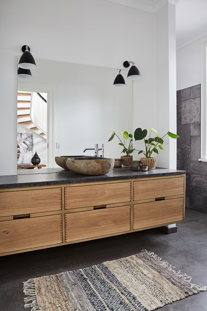 オールボーにある北欧スタイルのおしゃれな浴室 (フラットパネル扉のキャビネット、淡色木目調キャビネット、白い壁、コンクリートの床、ベッセル式洗面器) の写真