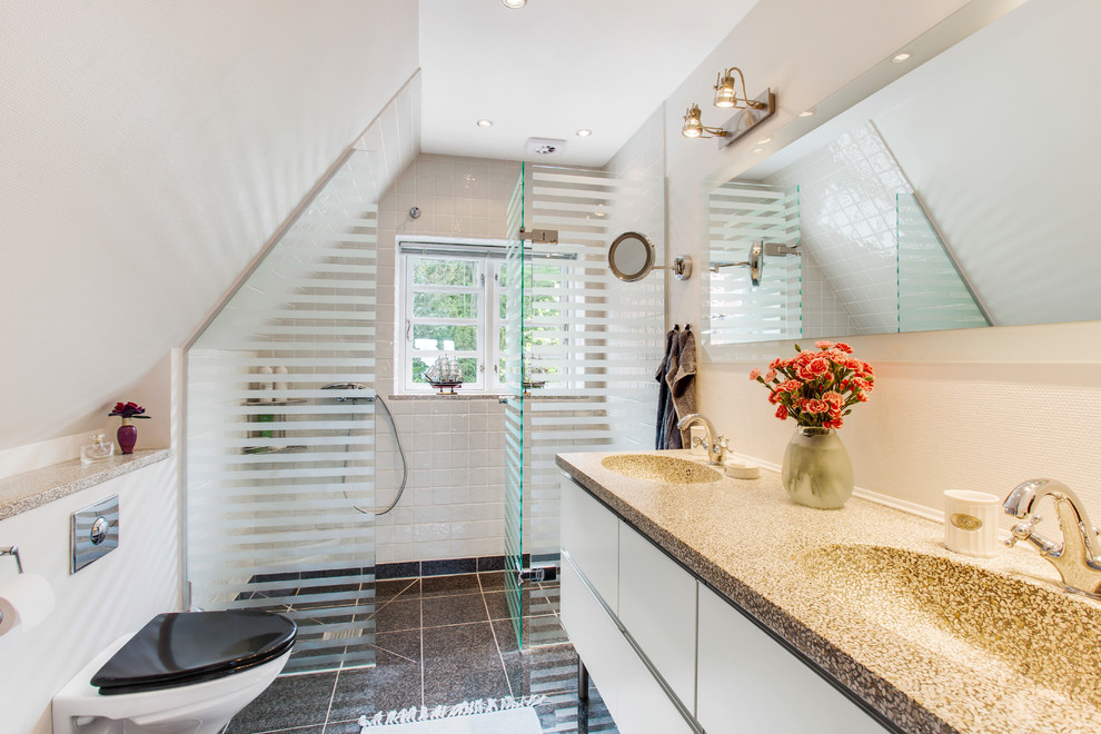 Exempel på ett mellanstort modernt badrum med dusch, med ett integrerad handfat, släta luckor, en kantlös dusch, en toalettstol med separat cisternkåpa, beige väggar, beige skåp, svart kakel, stenkakel, klinkergolv i keramik och granitbänkskiva