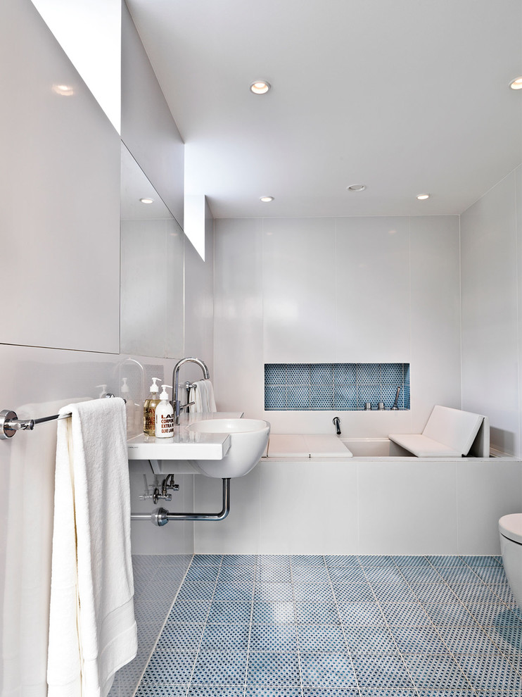 Ejemplo de cuarto de baño contemporáneo con baldosas y/o azulejos azules, paredes blancas y lavabo suspendido