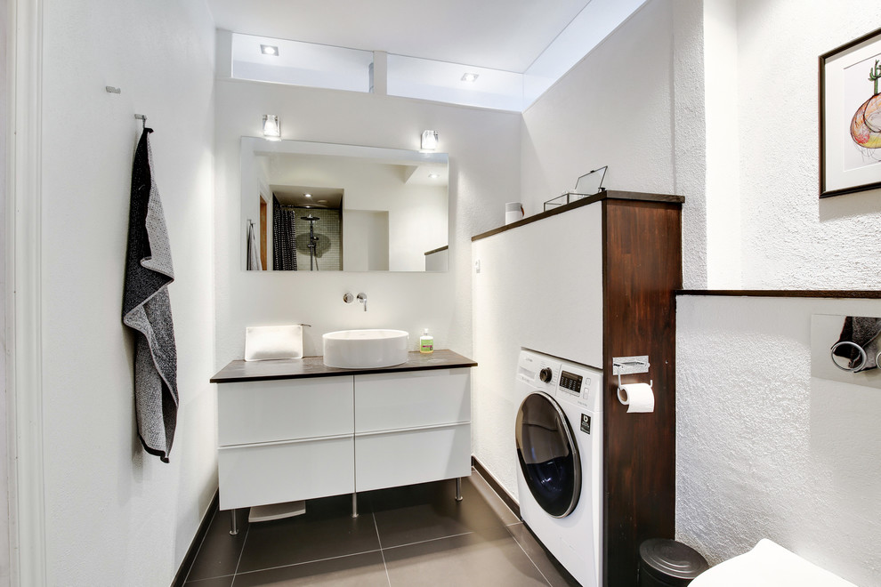 Idee per una piccola stanza da bagno design con ante lisce, ante bianche, pareti bianche, lavabo integrato, top in legno, pavimento grigio e lavanderia