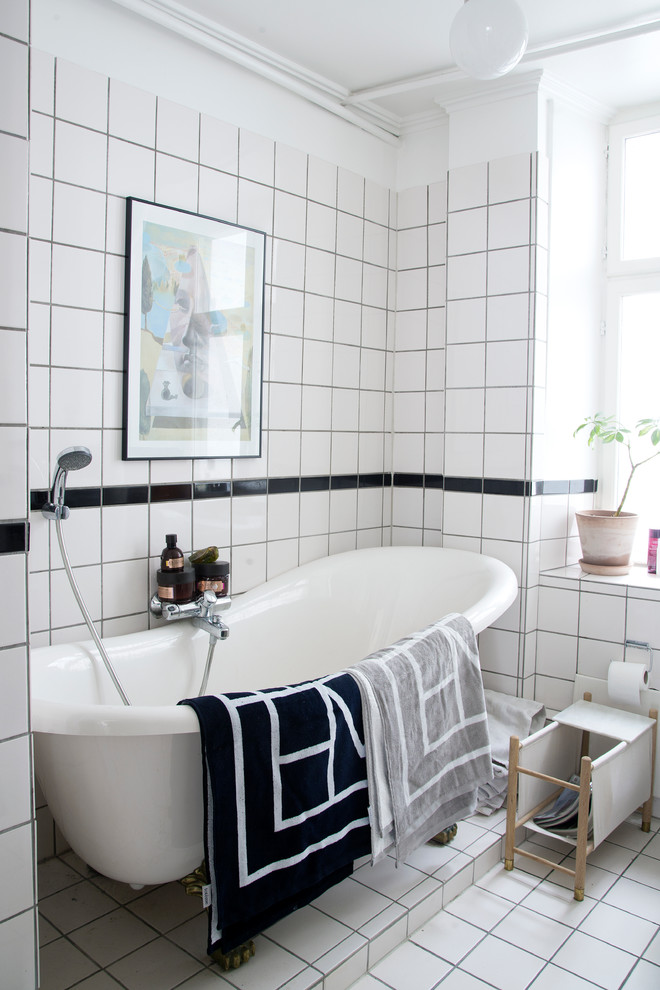 Imagen de cuarto de baño principal escandinavo de tamaño medio con bañera exenta, baldosas y/o azulejos blancos, baldosas y/o azulejos de porcelana, paredes blancas y suelo de baldosas de porcelana
