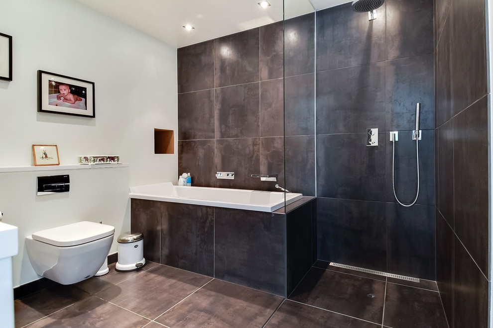 На фото: большая главная ванная комната в современном стиле с накладной ванной, открытым душем, инсталляцией, белыми стенами, серой плиткой, каменной плиткой, полом из керамической плитки и открытым душем с