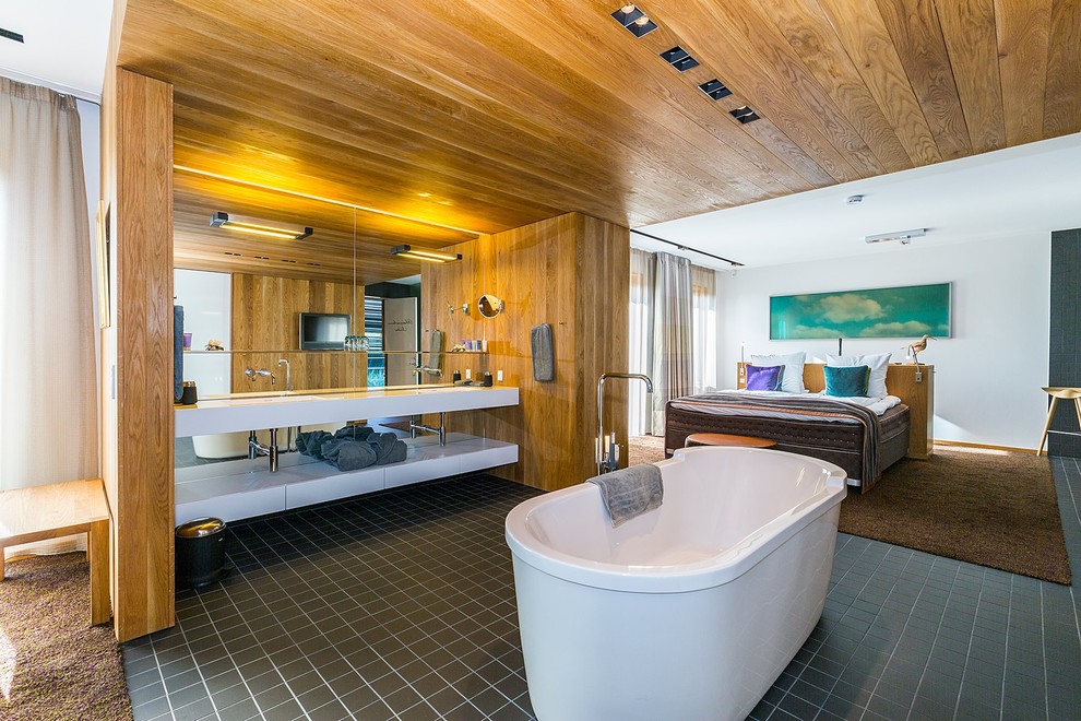 Exemple d'une salle de bain principale tendance avec une baignoire indépendante et un carrelage noir.