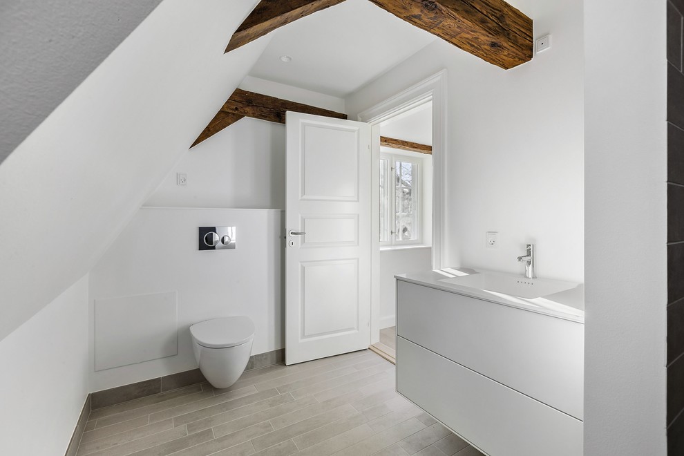 Idéer för att renovera ett mellanstort nordiskt vit vitt badrum, med släta luckor, vita skåp, en vägghängd toalettstol, vita väggar, bänkskiva i kvartsit och grått golv
