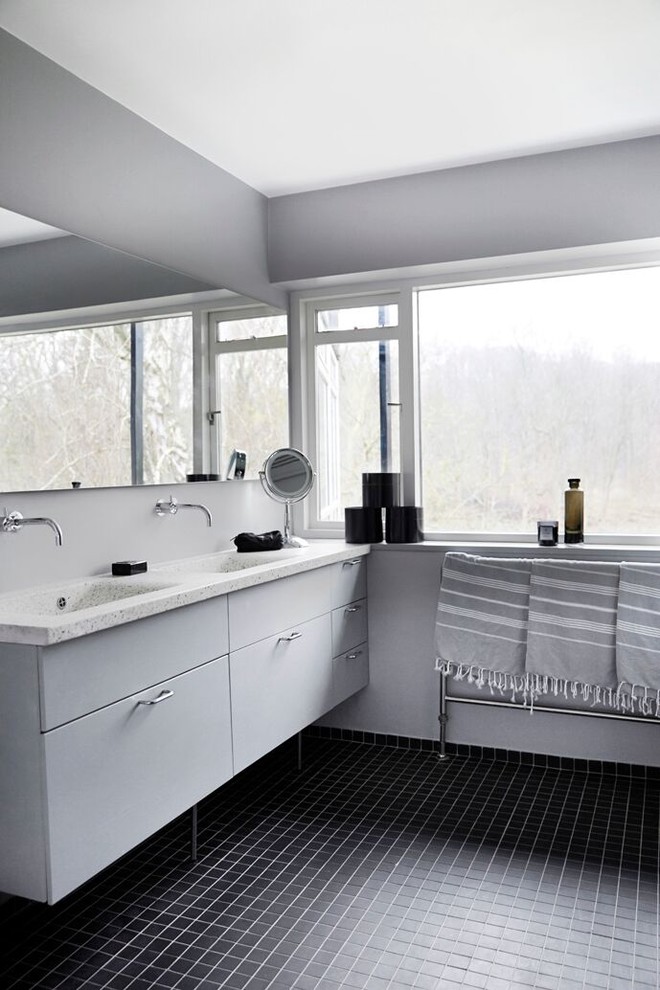 Diseño de cuarto de baño principal escandinavo de tamaño medio con armarios con paneles lisos, puertas de armario grises, paredes grises, suelo de baldosas tipo guijarro, lavabo integrado y encimera de cuarcita
