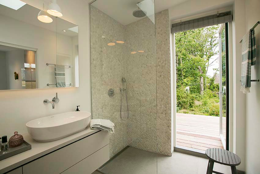 Пример оригинального дизайна: главная ванная комната среднего размера в скандинавском стиле с плоскими фасадами, серыми фасадами, инсталляцией, разноцветной плиткой, галечной плиткой, белыми стенами, полом из цементной плитки, настольной раковиной, серым полом, открытым душем, серой столешницей, тумбой под две раковины и подвесной тумбой