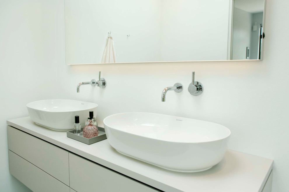 Inredning av ett skandinaviskt mellanstort grå grått en-suite badrum, med beige skåp, en öppen dusch, en vägghängd toalettstol, mosaik, vita väggar, cementgolv, grått golv och med dusch som är öppen