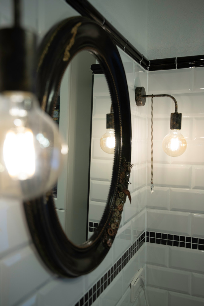 Пример оригинального дизайна: ванная комната среднего размера в стиле лофт с стеклянными фасадами, белыми фасадами, полновстраиваемой ванной, раздельным унитазом, черно-белой плиткой, плиткой кабанчик, белыми стенами, полом из керамической плитки, душевой кабиной, настольной раковиной, столешницей из нержавеющей стали, черным полом, шторкой для ванной и белой столешницей