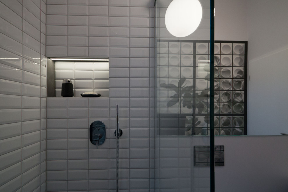 Inspiration pour une petite salle d'eau design avec un placard à porte plane, des portes de placard grises, une douche ouverte, WC suspendus, un carrelage blanc, des carreaux de céramique, un mur blanc, une vasque, un sol gris, meuble simple vasque, meuble-lavabo suspendu et du papier peint.