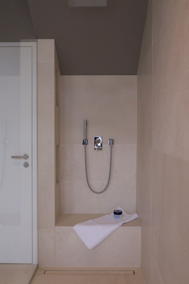 Foto de cuarto de baño actual de tamaño medio con ducha a ras de suelo, sanitario de pared, baldosas y/o azulejos beige, paredes grises, aseo y ducha, suelo beige, ducha abierta y lavabo suspendido